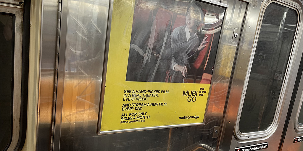 MUBI GO poster on a subway car.