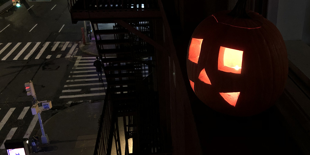 Pumpkin Jack O' Lantern above the city streets of New York City.